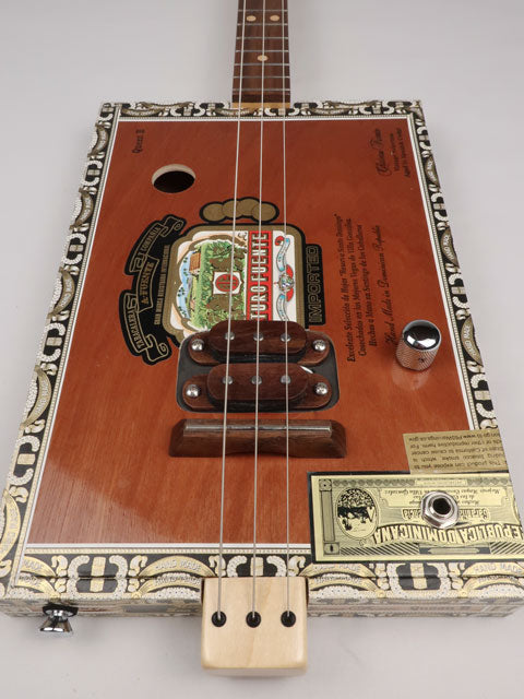 Front view of a 3 string cigar box guitar made with a Queen B Fuente cigar box. This cigar box guitar is handmade by Mike Snowden of Snowden Guitars.
