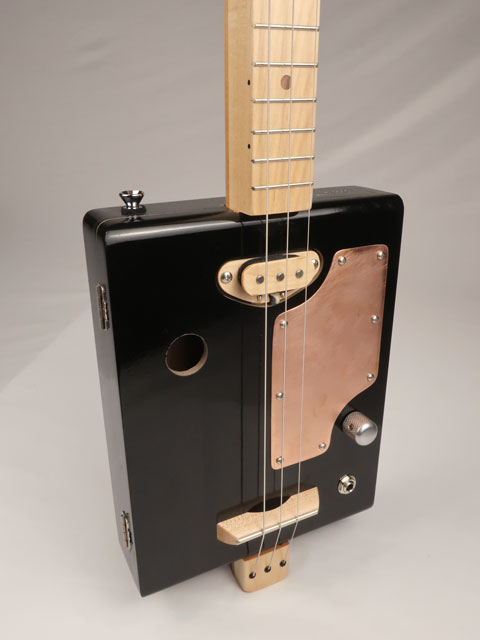 Front side view of a 3 string cigar box guitar. Handmade by Mike Snowden with copper pick guard and single coil pickup.