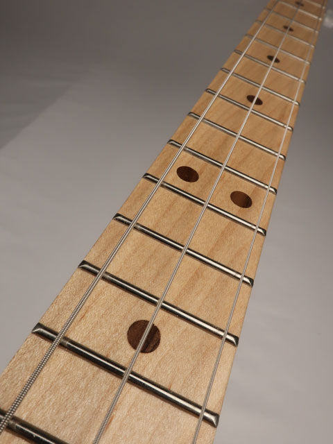Close up view of a 3 string cigar box guitar neck. Maple fretboard with walnut inlay made by Mike Snowden.