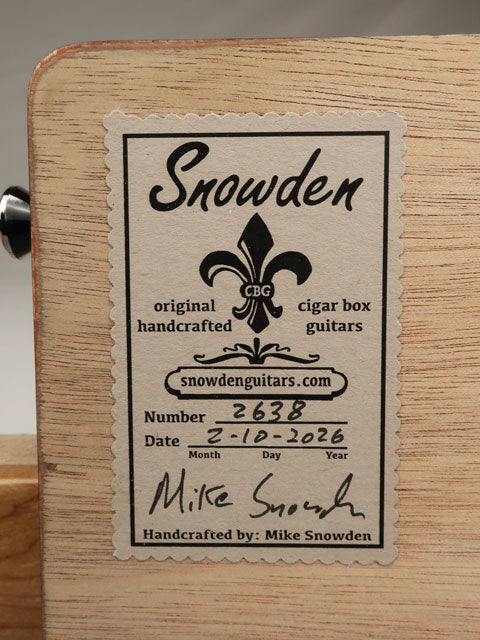 Snowden Cigar Box Guitars label on the back of a 3 string cigar box guitar. Maple neck and strap button are visible.