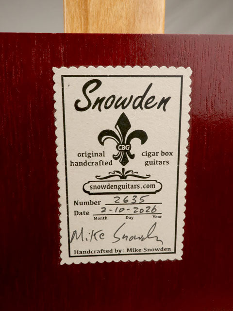 Snowden Guitars label on a cigar box guitar with a red finish. Handmade by Mike Snowden.