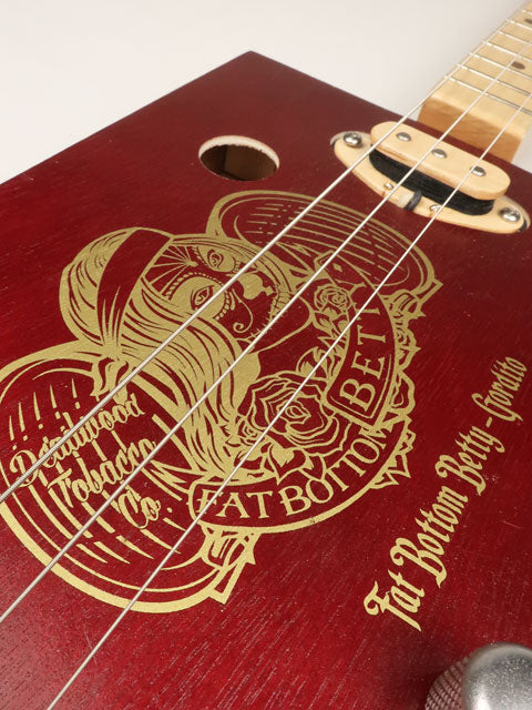 Fat Bottom Betty logo on front of a 3 string cigar box guitar. Handmade by Mike Snowden with a single coil pickup.