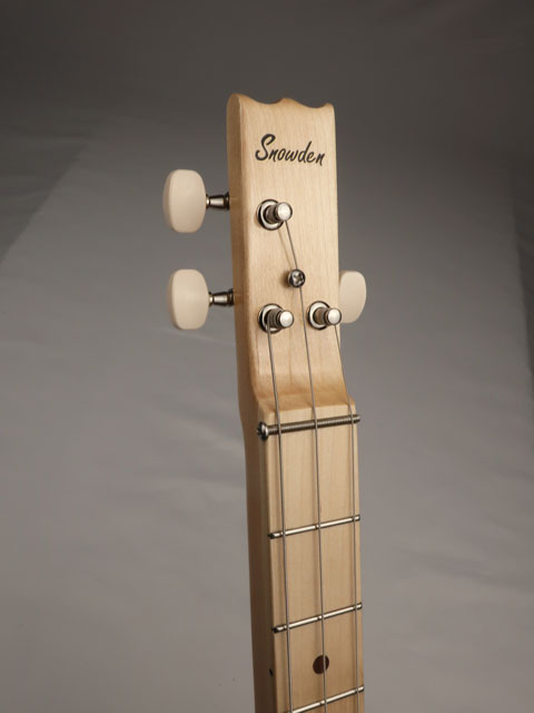 Front view of a 3 string cigar box guitar headstock. Snowden guitars sticker on the maple neck and male fretboard.