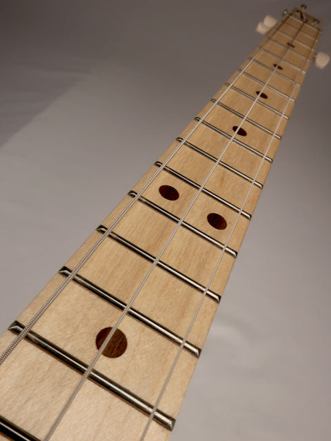 Close up view of a maple 3 string cigar box guitar neck with walnut inlay. handmade by Mike Snowden.