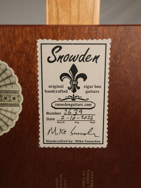Rear view of a Snowden Guitars label on a cigar box guitar handmade by Mike Snowden. 3 String wood cigar box with maple neck. 