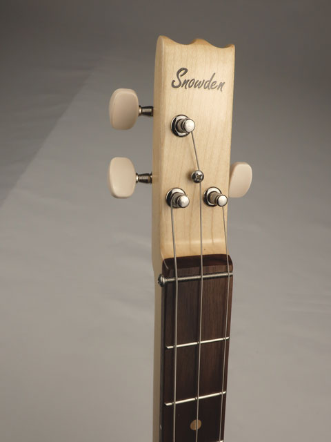 Close-up of a cigar box guitar neck with 'Snowden' branding on a gray background. 3 Strings with maple and walnut wood.