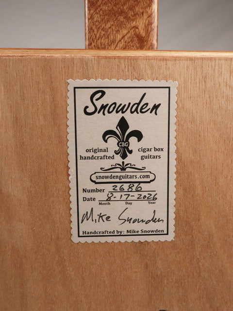Back view of a 3 string cigar box guitar label with Snowden Guitars printed on the back.