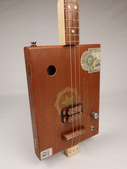Front view of a 3 string cigar box guitar made with a StillWell Star cigar box. This cigar box guitar is made with a sapele fretboard and maple inlay by Mike Snowden of Snowden Guitars.