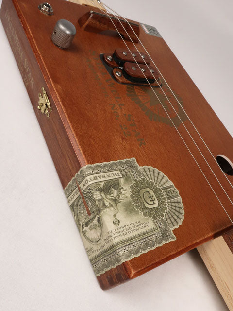 Side view of a 3 string cigar box guitar made with a StillWell Star cigar box. This cigar box guitar is made with a sapele fretboard and maple inlay by Mike Snowden of Snowden Guitars.