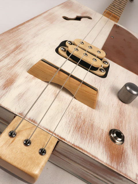 Front tilted view of a 3 string cigar box guitar made with a humbucker pickup and copper pick guard. This cigar box guitar is handmade by Mike Snowden of Snowden Guitars.