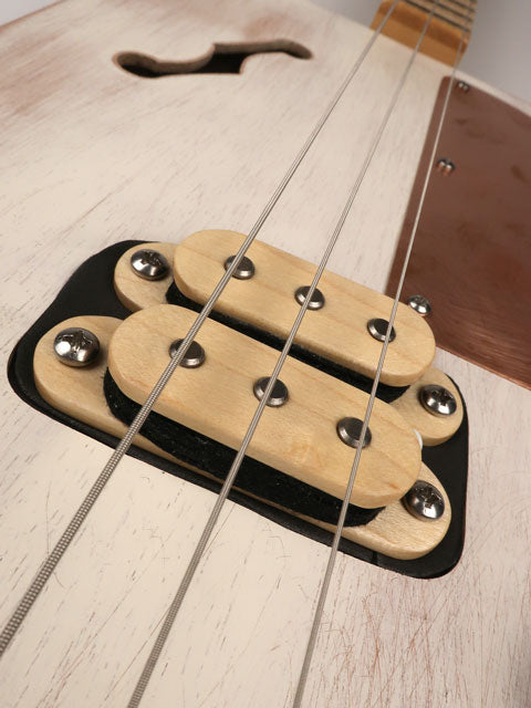 Closeup front view of a 3 string cigar box guitar humbucker pickup made with a humbucker pickup and copper pick guard. This cigar box guitar is handmade by Mike Snowden of Snowden Guitars.