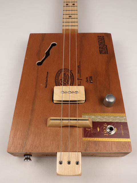 Front view of cigar box guitar with a P90 pickup handmade by Mike Snowden. This cigar box guitar is made with a Padron cigar box and a maple neck.