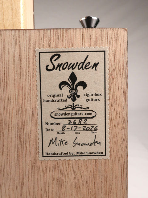 Back view of a cigar box guitar label with Snowden Guitars logo printed on it. The label shows the date and number of guitars made by Mike Snowden of Snowden Guitars.