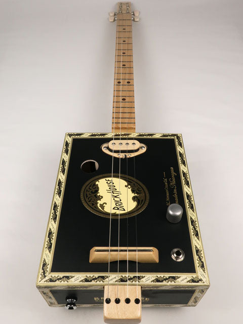 Front view of a 4 string cigar box guitar made with a Brick House cigar box. This cigar box guitar is made with a maple single coil pickup handmade Mike Snowden of Snowden Guitars.