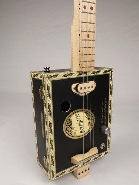 Front view of a 4 string cigar box guitar made with a Brick House cigar box. This cigar box guitar is made with a maple single coil pickup handmade Mike Snowden of Snowden Guitars.