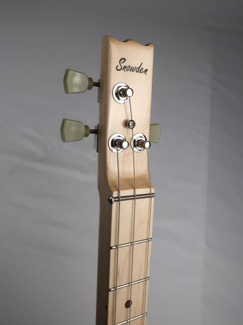 Close-up view of a cigar box guitar headstock. This 3 string cigar box guitar has a Snowden Guitars logo on the front with maple wood and Grover tuners. Handmade cigar box guitar by Mike Snowden of Snowden Guitars.