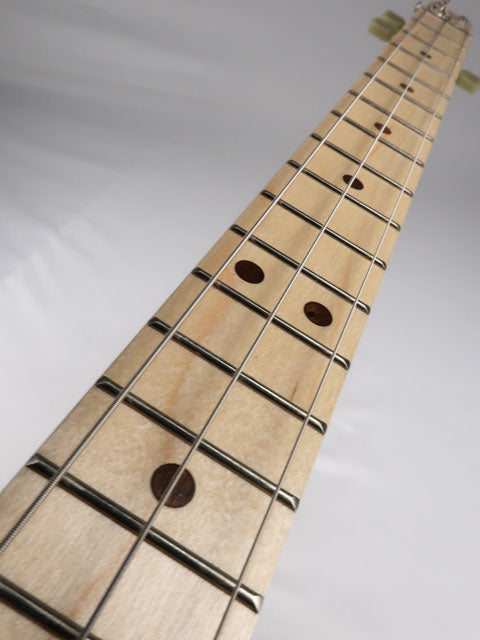 Close-up view of a 3 string cigar box guitar with maple fretboard and walnut inlay. This cigar box guitar is handmade by  Mike Snowden of Snowden Guitars.