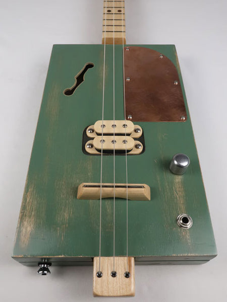 Front view of a 3 string cigar box guitar with a maple humbucker pickup and copper pick guard. This cigar box guitar as a maple neck and was handmade by Mike Snowden of Snowden Guitars.