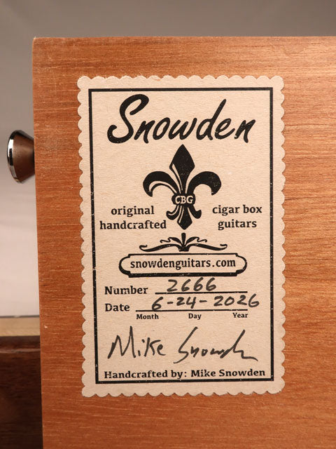 Back view of a cigar box guitar with a Snowden Guitars logo label on the back. Hand made by Mike Snowden of Snowden Guitars.