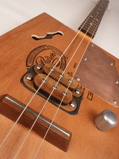 Front tilted view of a 3 string cigar box guitar made with a Padron cigar box. Handmade by Mike Snowden of Snowden Guitars.