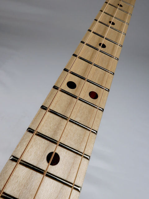 Close up view of a cigar box guitar fretboard and strings. Maple fretboard and walnut inlay handmade by Mike Snowden of Snowden Guitars.