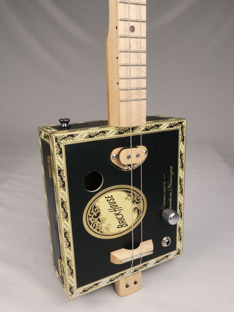Front tilted view of a 2 string cigar box guitar made with a Brick House cigar box. Handmade by Mike Snowden og Snowden Guitars.