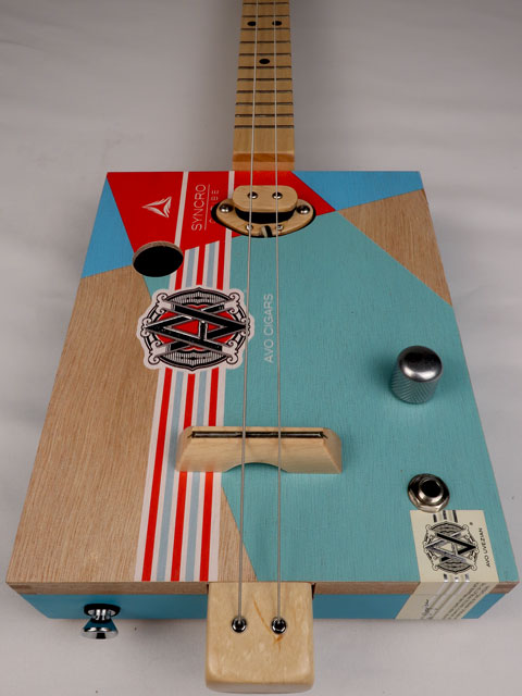 Front view of a 2 string cigar box guitar made with an AVO cigar box. Handmade by Mike Snowden of Snowden Guitars.