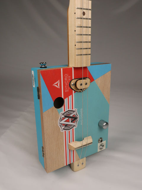 Front tilted view of a 2 string cigar box guitar made with an AVO cigar box. Handmade by Mike Snowden of Snowden Guitars.