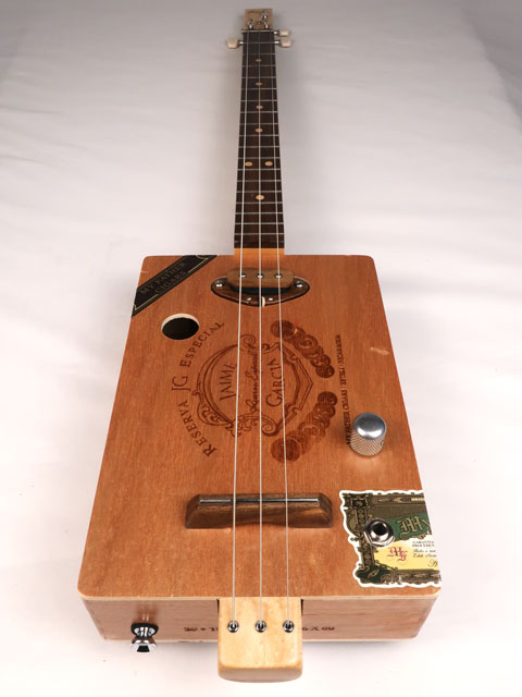 Front view of a 3 string cigar box guitar made with a Jaime Garcia cigar box. Handmade by Mike Snowden of Snowden Guitars.