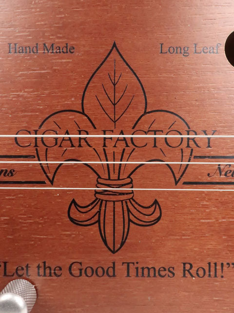 Close up front view of a 3 string cigar box guitar handmade by Mike Snowden of Snowden Guitars. This CBG is made with a New Orleans Cigar Factory cigar box.