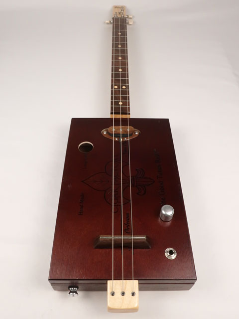 Front view of a 3 string cigar box guitar made with a New Orleans Cigar Factory cigar box handmade by Mike Snowden of Snowden Guitars.
