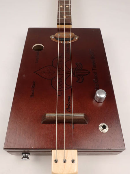 Front view of a 3 string cigar box guitar made with a New Orleans Cigar Factory cigar box handmade by Mike Snowden of Snowden Guitars.