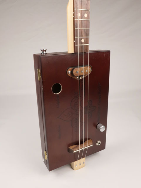 Front view of a 3 string cigar box guitar made with a New Orleans Cigar Factory cigar box handmade by Mike Snowden of Snowden Guitars.