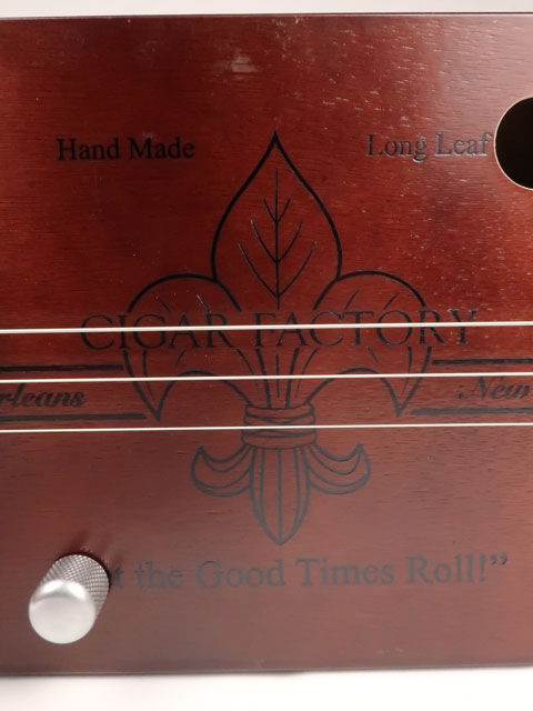 Close up front view of a 3 string cigar box guitar made with a New Orleans Cigar Factory cigar box handmade by Mike Snowden of Snowden Guitars.