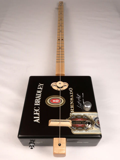 Front view of a one string cigar box guitar made with a Alec Bradley cigar box. Handmade by Mike Snowden of Snowden Guitars. 
