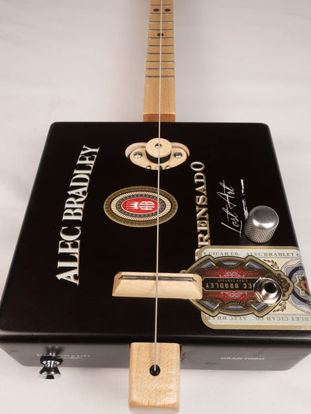 Front view of a one string cigar box guitar made with a Alec Bradley cigar box. Handmade by Mike Snowden of Snowden Guitars. 