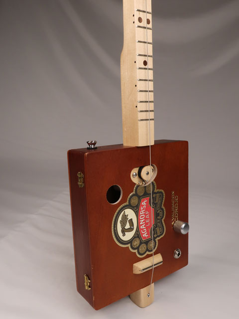 Front  tilted view of a single string diddly bow cigar box guitar made with a Aganorsa Leaf cigar box. Handmade by Mike Snowden of Snowden Guitars.