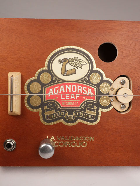 Close up front view of a single string diddly bow cigar box guitar made with a Aganorsa Leaf cigar box. Handmade by Mike Snowden of Snowden Guitars.