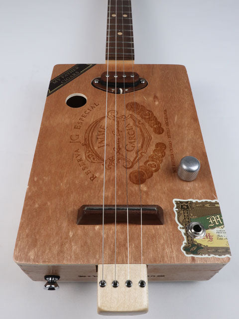 Front view of a Cigar Box Guitar handmade by Mike Snowden. This cigar box guitar is made from a Jaime Garcia cigar box with a walnut single coil pickup.