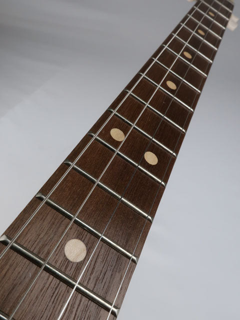 Close-up view of a walnut 4 string cigar box guitar fretboard with maple inlay. Handmade by Mike Snowden.