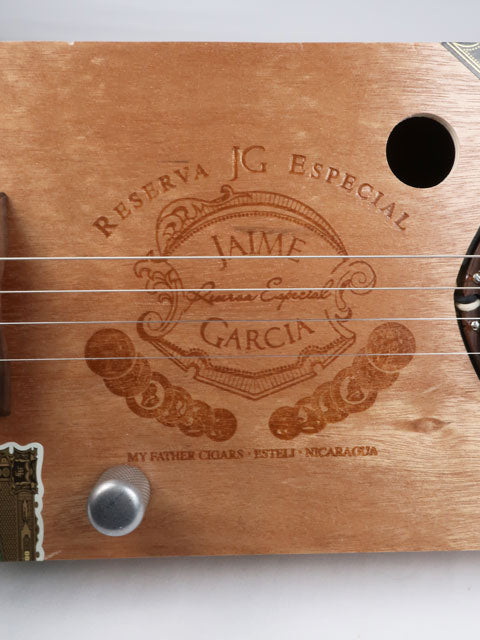 Front view of a Cigar Box Guitar handmade by Mike Snowden. This 4 string cigar box guitar is made from a Jaime Garcia cigar box.