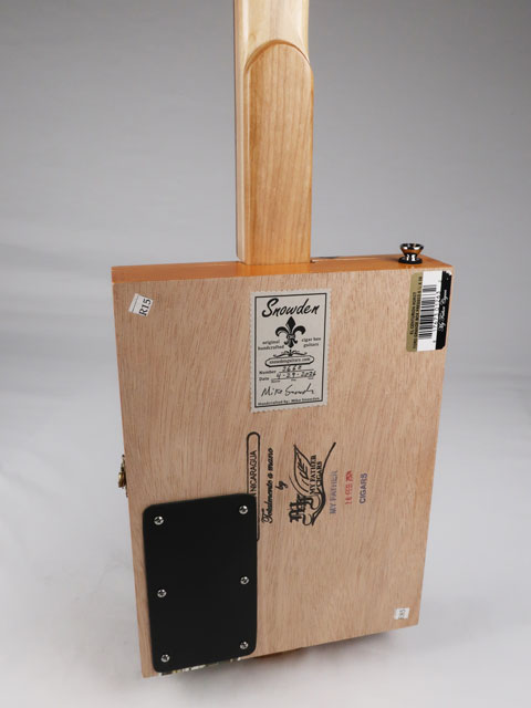 Back view of a cigar box guitar with a Snowden Guitars logo on the back. This cigar box guitar has a maple neck and a cherry heel handmade by Mike Snowden of Snowden Guitars.