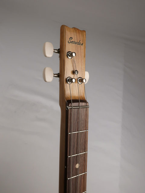 Front view of a cigar box guitar headstock with a Snowden Guitars logo on the front. This cigar box guitar is made with a walnut fretboard and a hard maple neck handmade by Mike Snowden.
