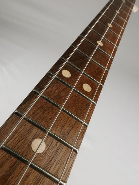 Close up view of a 3 string cigar box guitar with a walnut fretboard. This cigar box guitar was handmade by Mike Snowden of Snowden Guitars.