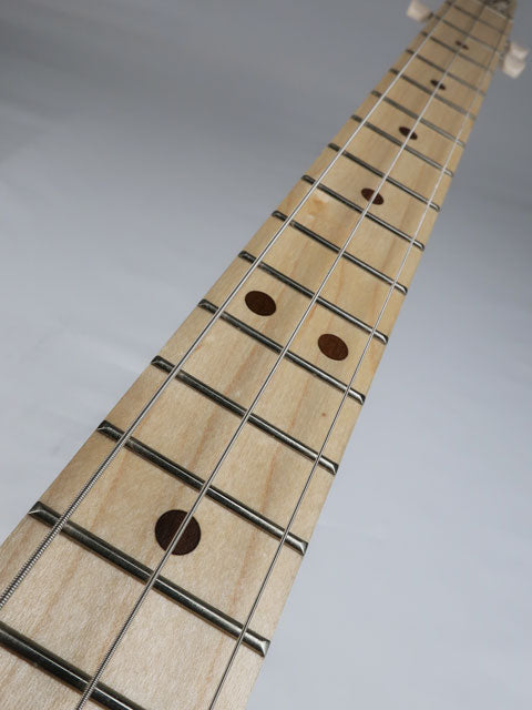 Close up of a 3 string cigar box guitar fret board and neck. This maple neck cigar box guitar has a maple fretboard with frets and walnut inlay.