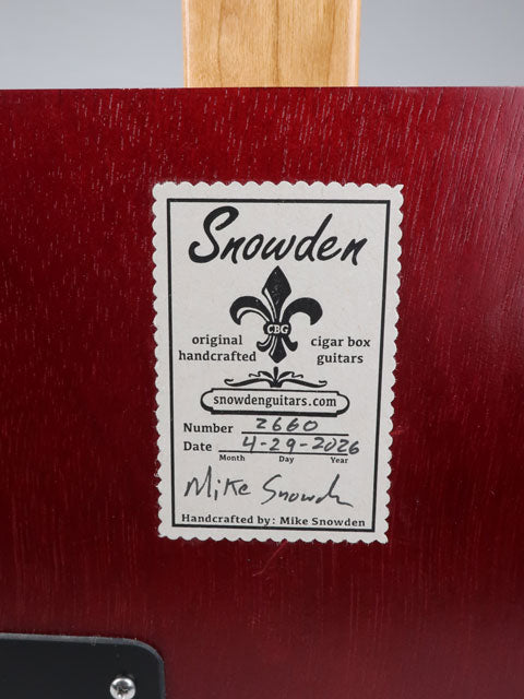 Close up back view of a cigar box guitar with a Snowden Guitars label. This sticker on the back shows Snowden Guitars, the date and number of this cigar box guitar.