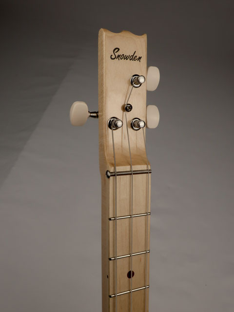 Close-up of a cigar box guitar neck  and headstock with 'Snowden' branding on a gray background.