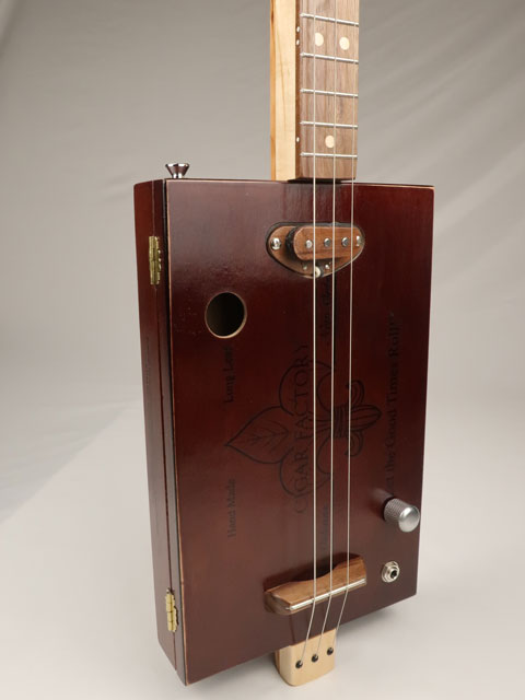 Front tilted view cigar box guitar 3 string new cigar factory with single coil pickup. Handmade by Mike Snowden.