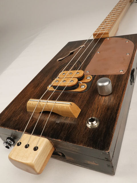 Close-up of a wooden cigar box guitar with a focus on the body and neck. Made by Mike Snowden with a Padron cigar box.