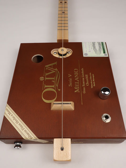 Front view of a one string cigar box guitar diddly bow cbg made with an Oliva cigar box. This cigar box guitar is handmade by Mike Snowden of Snowden Guitars.